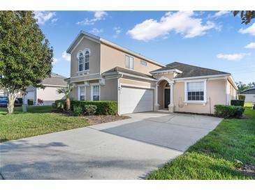 Charming two-story home featuring a well-manicured lawn and a paved driveway leading to the attached garage at 629 Copeland Dr, Haines City, FL 33844