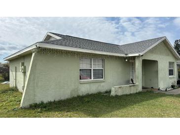 Charming single-story home with well-maintained gray roof, light green exterior, and green lawn at 91 W Cedarwood Cir, Kissimmee, FL 34743