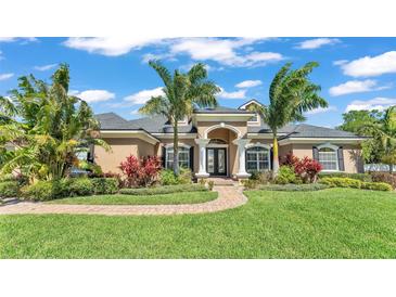 Charming home with lush landscaping, manicured lawn, and a welcoming brick walkway at 9502 Waterford Oaks Blvd, Winter Haven, FL 33884