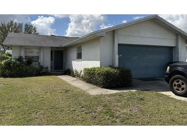 Inviting single-story home features a well-maintained lawn and a convenient two-car garage at 1411 Grand Cayman Cir, Winter Haven, FL 33884