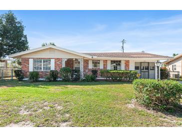 Charming single-story brick home with a well-maintained lawn and classic shutters on a sunny day at 205 Kilmer Ln, Winter Haven, FL 33884