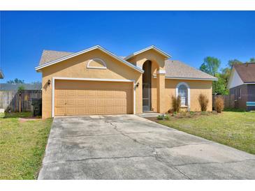 Inviting single-story home with a two-car garage, arched entryway, and a well-kept lawn and long driveway at 3430 Cove E Ct, Winter Haven, FL 33880