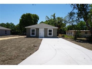 Charming home featuring a new concrete driveway, modern paint, and meticulously maintained landscaping at 3438 Avenue E Nw, Winter Haven, FL 33880