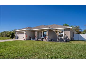 Inviting single-story home boasts a well-manicured lawn, neutral exterior, and charming front porch at 3467 Sutton Ridge St, Lakeland, FL 33810