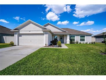 Charming single-story home with a well-manicured lawn and attached two-car garage at 447 Lanham Dr, Winter Haven, FL 33881