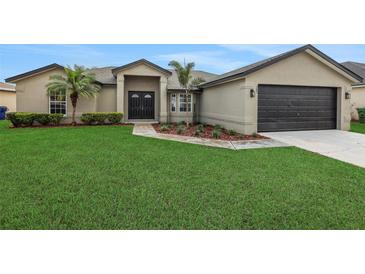 Charming single-story home with lush green lawn and attached two-car garage at 583 Drayton Rd, Winter Haven, FL 33884