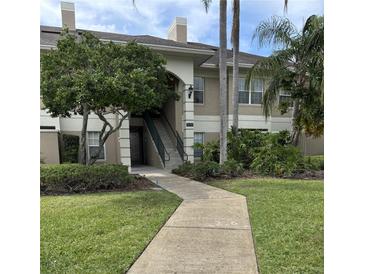 Inviting condo exterior with lush landscaping and a charming walkway leading to the entrance at 703 Eagle Pond Dr # 703, Winter Haven, FL 33884