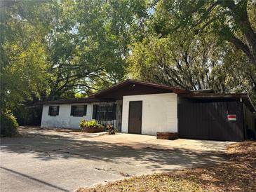 Cozy one-story home with mature trees and a driveway, offering a serene setting at 909 Spirit Lake Rd, Winter Haven, FL 33880