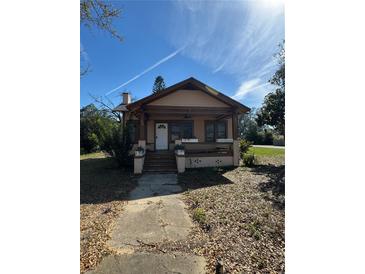 Charming bungalow with a covered front porch, steps, and a walkway leading to the house at 334 Main St, Haines City, FL 33844