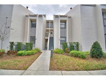 Inviting condo exterior with well-maintained landscaping and a charming walkway to the entrance at 404 Laurel Cove Way # 404, Winter Haven, FL 33884