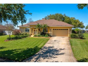 Charming single-story home with well-manicured lawn, mature trees, and inviting front entrance at 633 Hart Lake Dr, Winter Haven, FL 33884