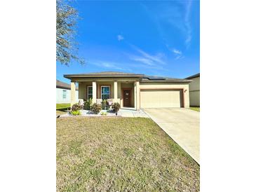 Charming single-story home featuring a well-maintained lawn, inviting front porch and attached two car garage at 1056 Naes Ln, Lake Wales, FL 33853