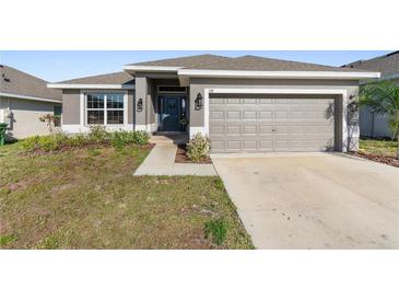Charming single-story home featuring a well-maintained lawn and a two-car garage at 135 Krenson Bay Loop, Winter Haven, FL 33881