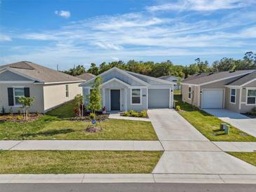 Charming single Gathering home with a well manicured lawn and driveway with beautiful blue sky at 1998 Sarah St, Winter Haven, FL 33884