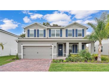 Charming two-story home features a well-manicured lawn, brick driveway, and eye-catching blue shutters at 3217 La Salle St, Winter Haven, FL 33884