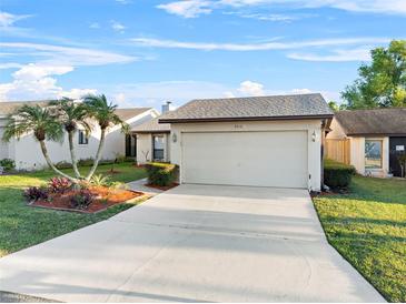 Charming single-story home with a two-car garage, lush landscaping, and well-manicured lawn at 4016 Cypress S Lndg, Winter Haven, FL 33884