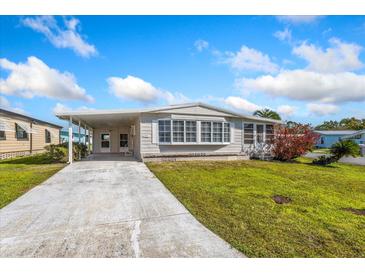 Charming single-story home with a covered carport and well-manicured lawn at 6433 Jacaranda Ne Ave, Winter Haven, FL 33881