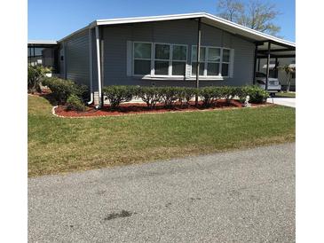 Charming single-story home featuring well-maintained landscaping and covered parking at 6515 Raintree Ne Ln, Winter Haven, FL 33881
