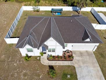 Beautiful aerial view of a charming home with a dark brown roof and a well-maintained lawn and full fence at 747 Fraser Ct, Kissimmee, FL 34759