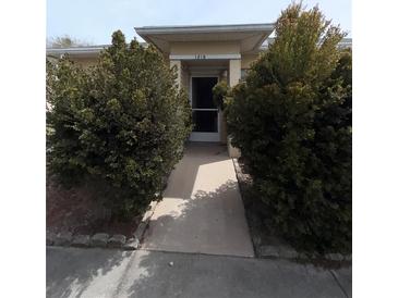Inviting front entrance with well-maintained landscaping leading to the front door at 1219 Club Cir, Lakeshore, FL 33854