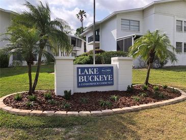 Lake Buckeye Condominiums with a well-maintained lawn, landscaping, and palm trees in a sunny Florida community at 1550 11Th Ne St # A2, Winter Haven, FL 33881