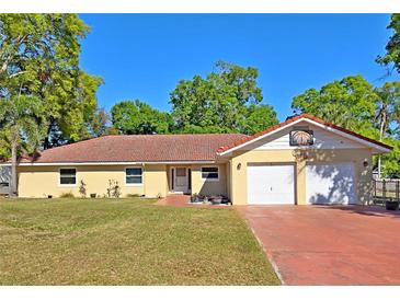 Charming single-story home with a well-manicured lawn, a red tile roof and a two-car garage at 218 Omaha St S S St, Lake Hamilton, FL 33851