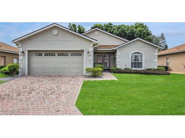 Charming single-story home featuring a well-maintained lawn and a brick-paved driveway leading to a two-car garage at 4063 Birkdale Dr, Lake Wales, FL 33859