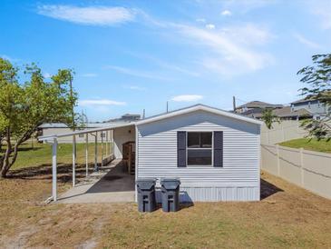 Exterior view of home with white siding and a covered carport at 4957 Old Lucerne Park Rd, Winter Haven, FL 33881