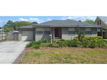 Charming single-story home with a well-maintained lawn, complemented by a one car garage and a red front door at 614 Chatham Dr, Lakeland, FL 33803