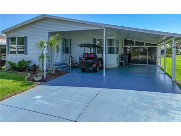 Charming home featuring a covered carport, an enclosed lanai and well-maintained landscaping at 6603 Scenic Point Se Dr, Winter Haven, FL 33884