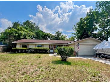 Charming single-story home features an attached garage and well-maintained landscaping at 799 W Lake Otis Dr, Winter Haven, FL 33880