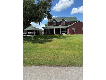 Charming two-story brick home with a spacious, well-manicured front lawn and covered porch at 1403 Hidden Creek Ln, Winter Haven, FL 33880