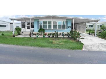 Charming home featuring a well-maintained lawn and an array of potted plants at 2055 S Floral Ave # 42, Bartow, FL 33830