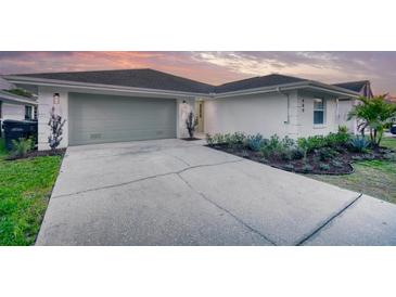 Charming single-story home featuring a two-car garage, well-manicured landscaping, and a freshly painted exterior at 409 Greenfield Rd, Winter Haven, FL 33884