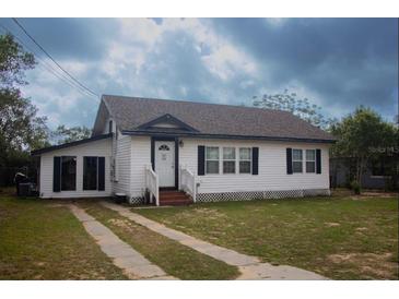 Charming one-story home featuring a well-maintained lawn and a classic white exterior, creating a welcoming curb appeal at 420 N 5Th St, Lake Wales, FL 33853