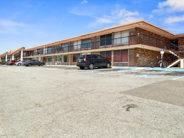 Motel exterior featuring a two-story building, expansive parking lot, and architectural details under a clear blue sky at 43420 Highway 27 # 445, Davenport, FL 33837