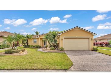 Charming single-story home with a well-manicured lawn, paved driveway, and lush tropical landscaping at 5341 Hogan Ln, Winter Haven, FL 33884