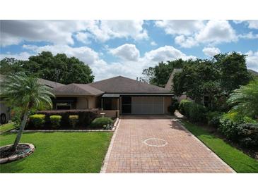 Single-story home with a brick driveway, well-maintained landscaping, and a covered entryway, offering classic curb appeal at 571 Saint Andrews Rd, Winter Haven, FL 33884