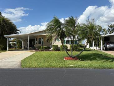 Charming single-story home with well-manicured lawn, lush landscaping, carport, and welcoming curb appeal at 6107 Grand Oaks Se Dr, Winter Haven, FL 33884