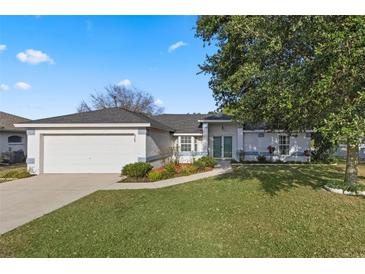 Charming single-story home with a well-maintained lawn, mature tree, and two-car garage at 6560 Horizon Point Dr, Lakeland, FL 33813
