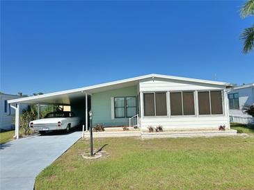 Charming single-story home featuring a carport and an enclosed sunroom at 11 Navel Dr, Winter Haven, FL 33884