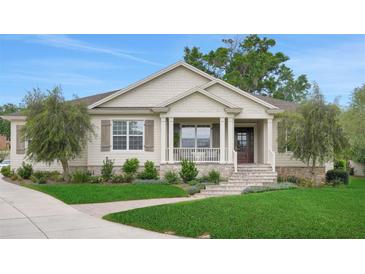 Charming home with a covered front porch, well-maintained lawn and beautiful landscaping at 1162 E Highland Dr, Lakeland, FL 33813