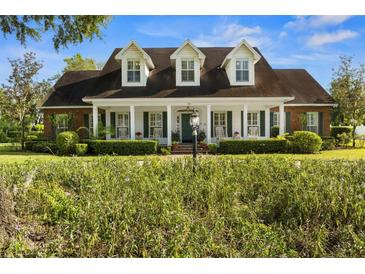 Inviting home featuring a manicured front yard and a charming porch with rocking chairs at 195 E Conant St, Bartow, FL 33830