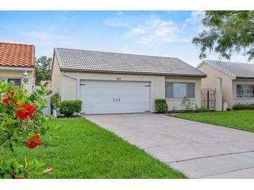 Charming home featuring a white tile roof, well-manicured lawn, and attached two-car garage at 259 Mariposa, Winter Haven, FL 33884