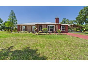Charming single-story brick home featuring a well-manicured lawn, covered entry, and a classic brick chimney at 2726 Prine Rd, Lakeland, FL 33810