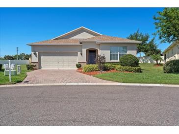 Charming single-story home with a well-manicured lawn, two-car garage, and a brick driveway at 3565 Raleigh Dr, Winter Haven, FL 33884