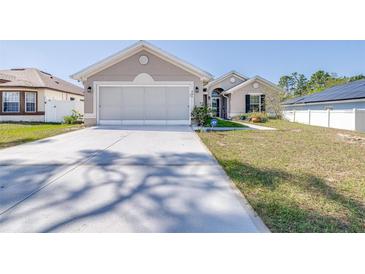 Charming single-story home featuring a wide driveway and well-maintained front lawn, with neutral stucco and white trim at 404 Rio Grande Ct, Poinciana, FL 34759