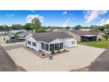 Charming home exterior with screened porch, white gravel landscaping, and convenient storage shed at 4228 Nandina St, Lake Wales, FL 33898