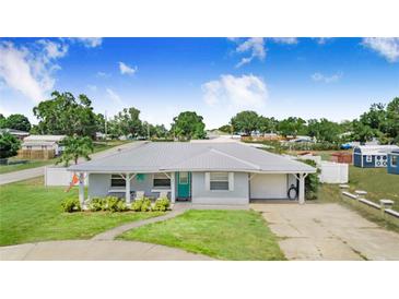 Charming single-story home with a well-manicured lawn and metal roof, exuding curb appeal at 498 W 7Th St, Frostproof, FL 33843