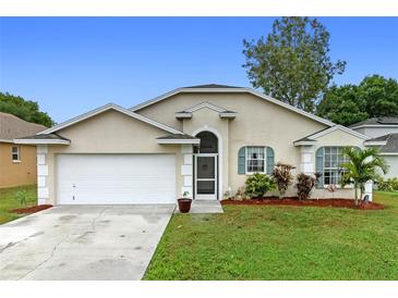 Charming single-story home with a two-car garage, beautiful landscaping, and a well-maintained lawn at 59 Saint Kitts Cir, Winter Haven, FL 33884